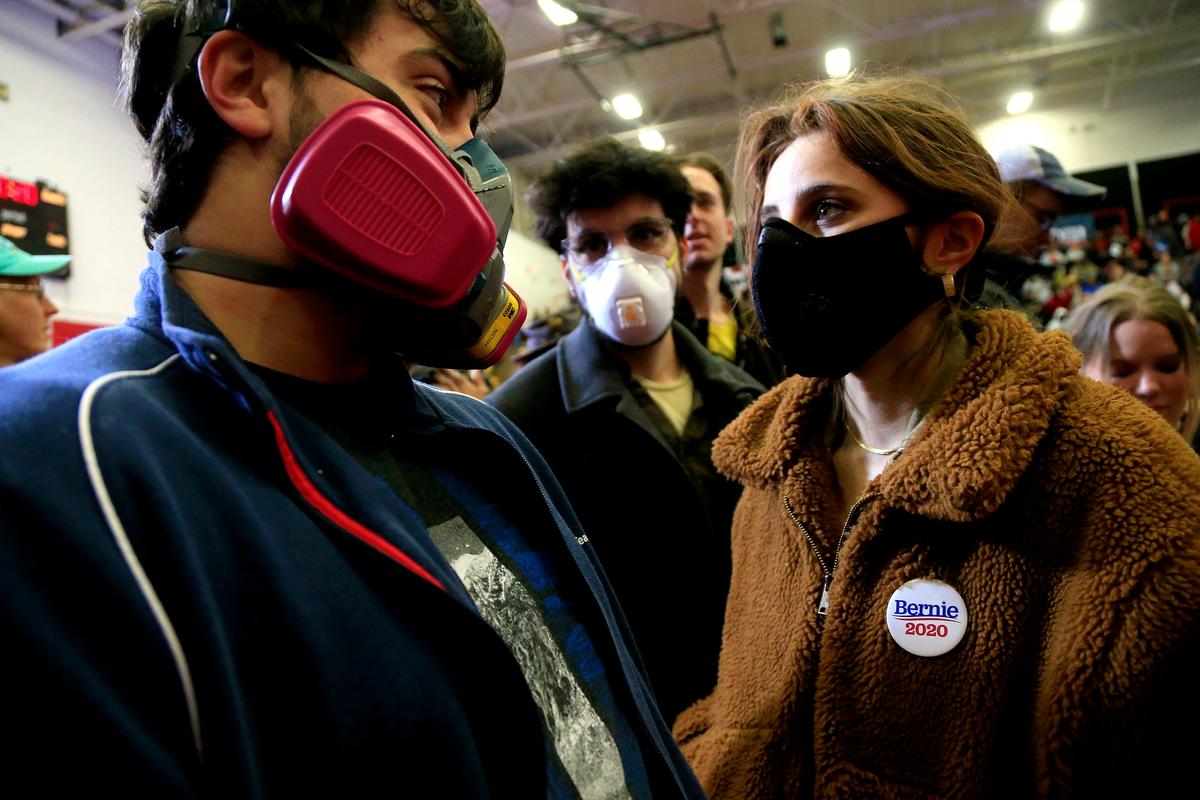 Concerned about the spread of COVID-19 in large gatherings, students from the University of North Carolina School of the Arts wear respiratory masks as they wait for Democratic presidential candidate Sen. Bernie Sanders (I-VT) to speak to supporters during a rally and march to early vote in Winston-Salem, North Carolina, on Feb. 27, 2020. (Brian Blanco/Getty Images)