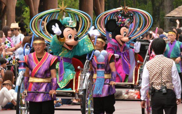 Disney characters Mickey Mouse (2nd L) and Minnie Mouse (2nd R) dressed in "Tanabata" or the Star Festival costumes wave from rickshaws as they greet guests along the parade route at Tokyo Disneyland in Urayasu, suburban Tokyo on June 30, 2015. (KAZUHIRO NOGI/AFP via Getty Images)