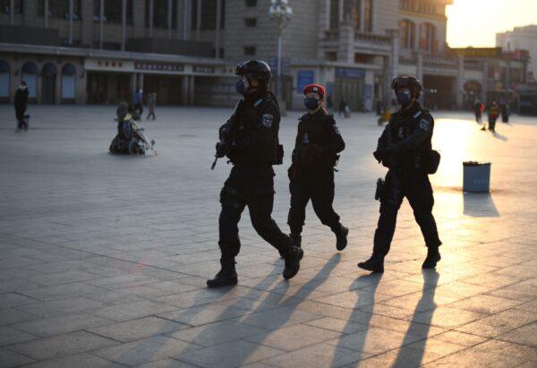 Policemen, wearing protective facemasks, patrols around Beijing Railway Station on Jan. 30, 2020. (Noel Celis/AFP via Getty Images)