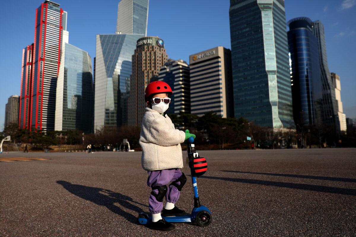 A South Korean child wears a mask to prevent catching the coronavirus (COVID-19) while riding a scooter in Seoul, South Korea on Feb. 27, 2020. (Chung Sung-Jun/Getty Images)