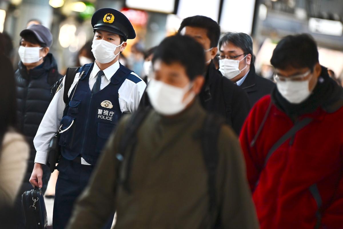 Mask-clad commuters make their way to work during morning rush hour at the Shinagawa train station in Tokyo, Japan, on Feb. 28, 2020. (Charly Triballeau/AFP via Getty Images)