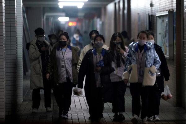 Workers wearing protective masks walk outside their dormitory, in an electronics manufacturing factory in Shanghai, China, on Feb. 12, 2020. (Aly Song/Reuters)