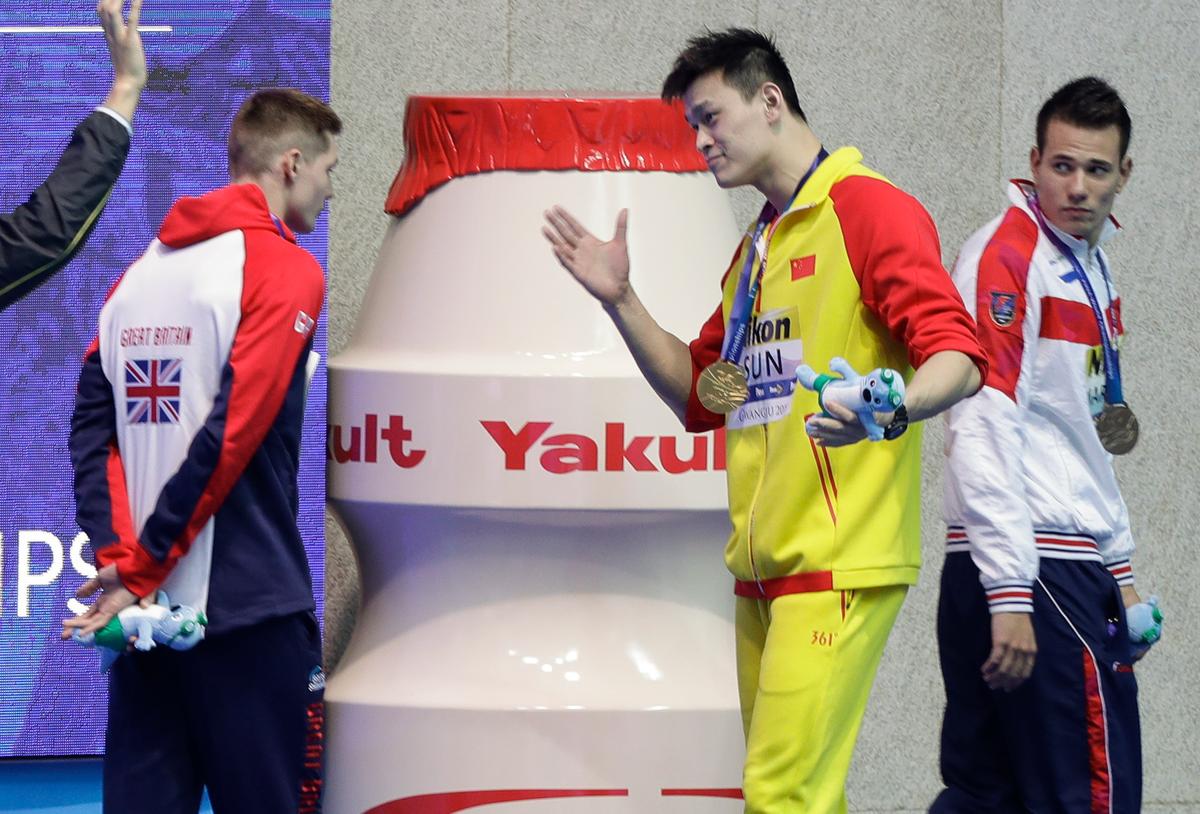 Gold medalist China's Sun Yang, center, gestures to Britain's bronze medalists Duncan Scott, left, following the medal ceremony in the men's 200m freestyle final at the World Swimming Championships in Gwangju, South Korea, on July 23, 2019. (Mark Schiefelbein/AP Photo)