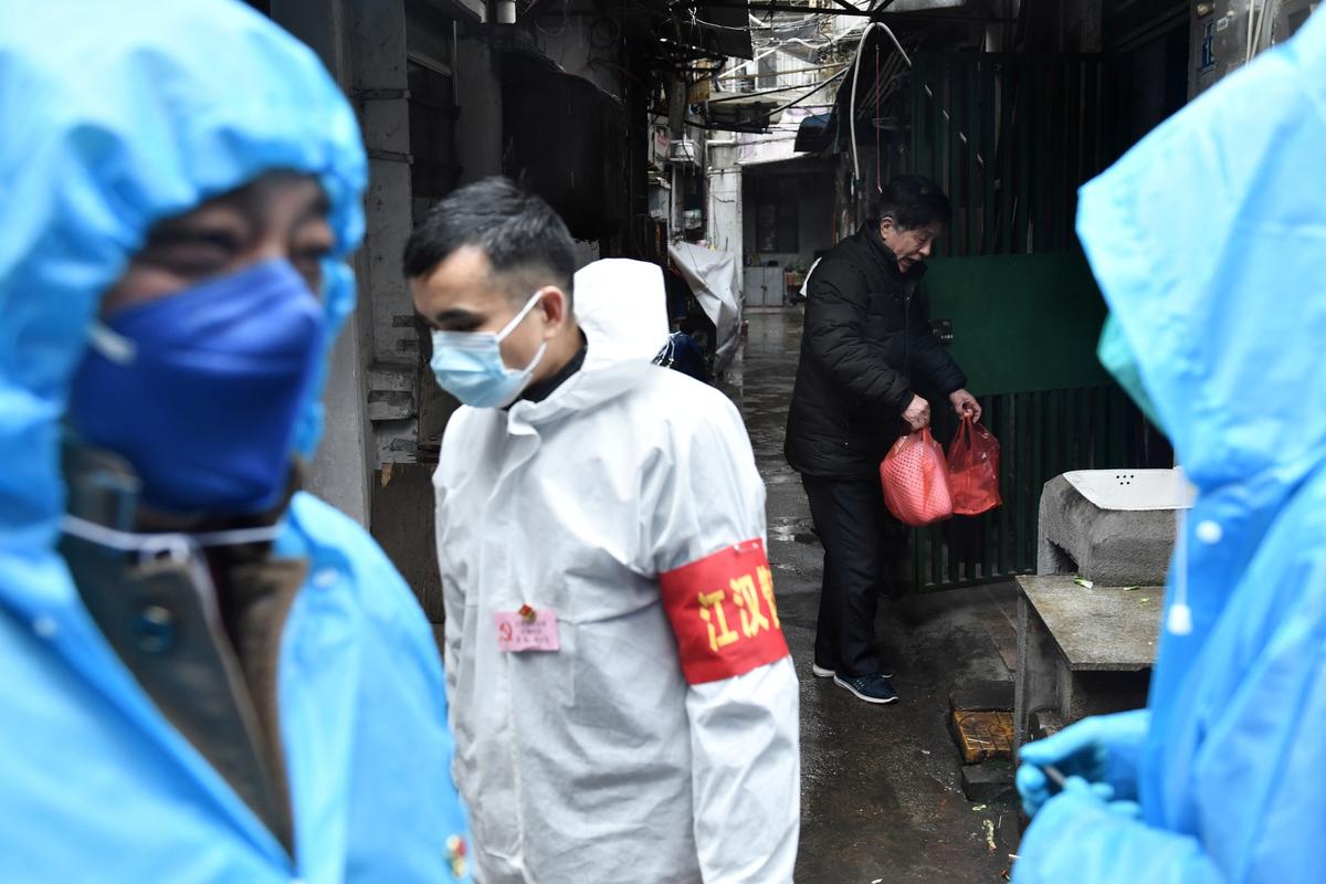 A man returns to his house with food delivered by volunteers at a residential area in Wuhan, the epicenter of the novel coronavirus outbreak in Hubei Province, China, on Feb. 28, 2020. (Stringer/Reuters)