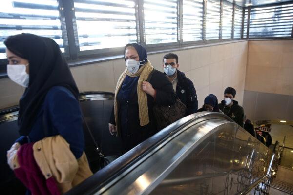 Iranian people wear protective masks to prevent spreading the coronavirus, as they climb an escalator in Tehran, Iran, on Feb. 29, 2020. WANA (West Asia News Agency)/Nazanin Tabatabaee via Reuters)