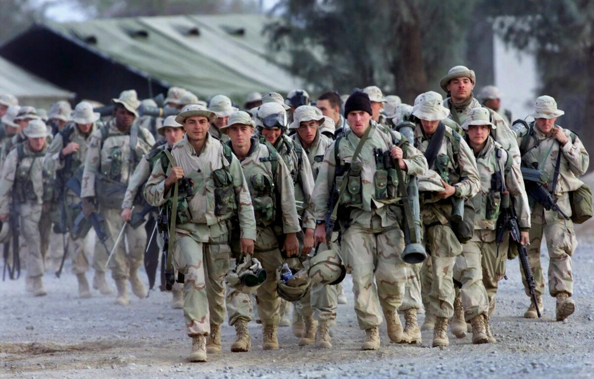  American Marines with full battle gear prepare to leave the U.S. military compound at Kandahar airport for a mission to an undisclosed location on Dec. 31, 2001. (John Moore/AP)