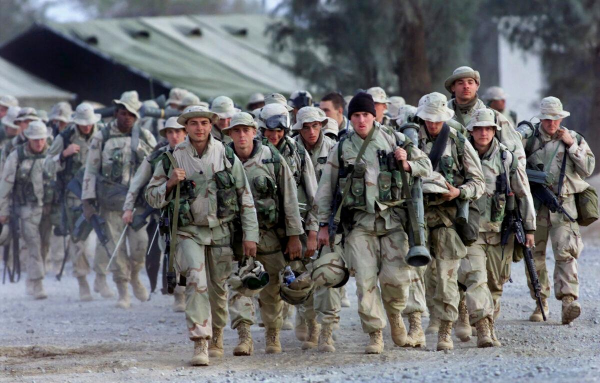 American Marines with full battle gear prepare to leave the U.S. military compound at Kandahar airport for a mission to an undisclosed location on Dec. 31, 2001. (John Moore/AP)