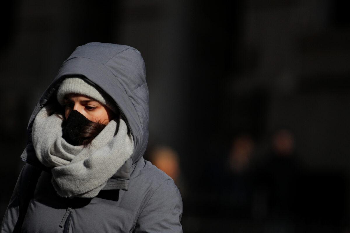 A woman wears a mask on Wall Street near the New York Stock Exchange in New York on Feb. 28, 2020. (Brendan McDermid/Reuters)