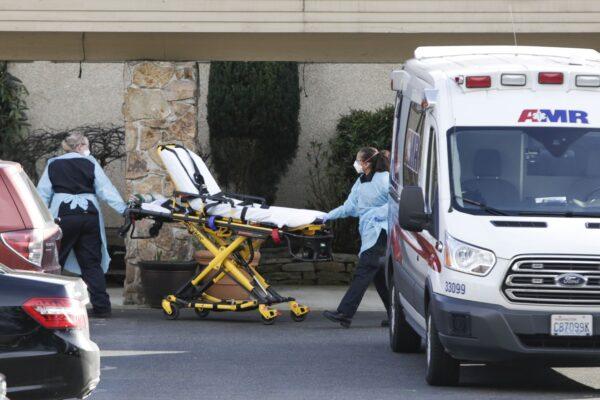 A stretcher is moved from an AMR ambulance to the Life Care Center of Kirkland, Washington state, in a file photo. (Jason Redmond/AFP via Getty Images)