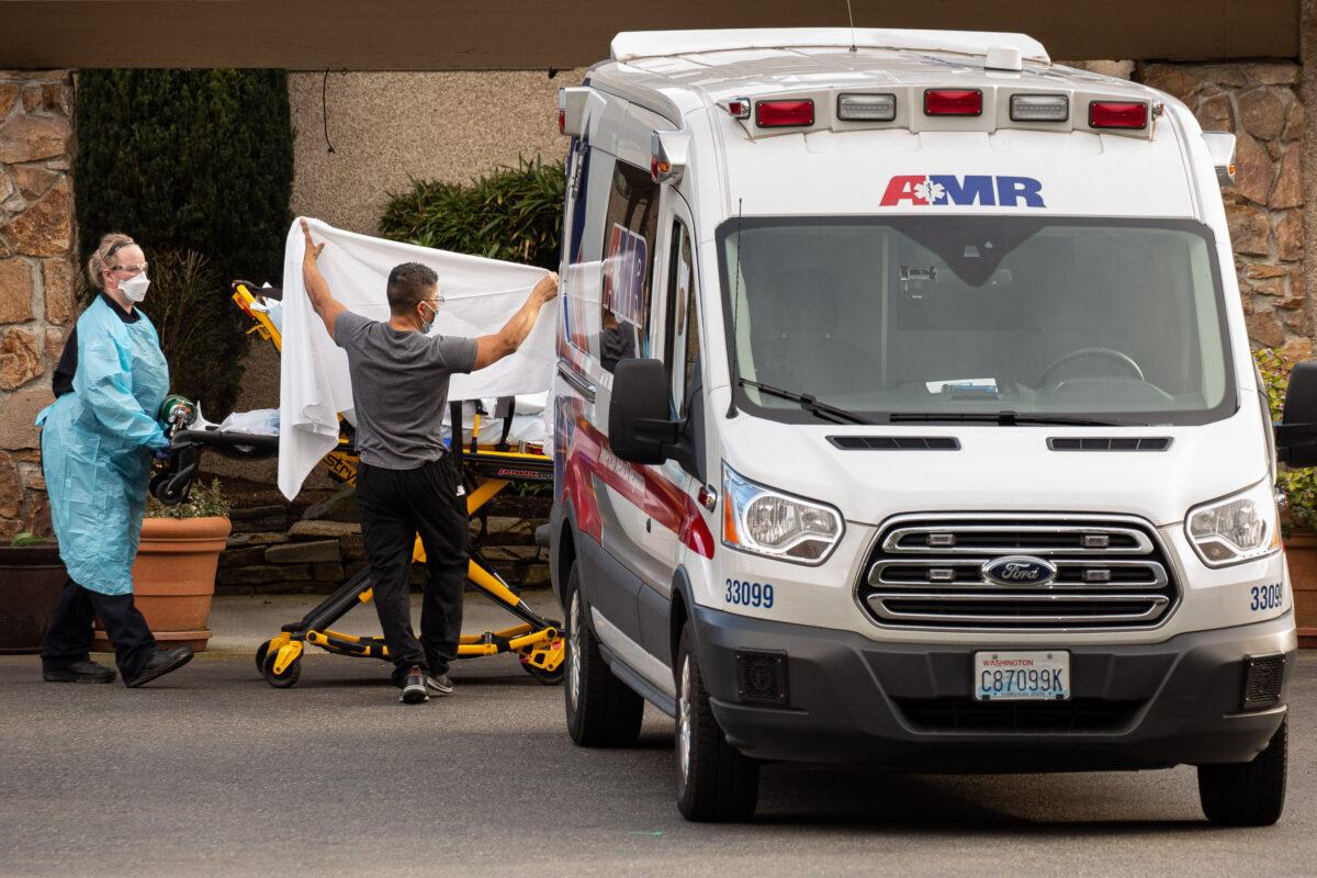 Healthcare workers transport a patient on a stretcher into an ambulance at Life Care Center of Kirkland on Feb. 29, 2020 in Kirkland, Washington. (Photo by David Ryder/Getty Images)