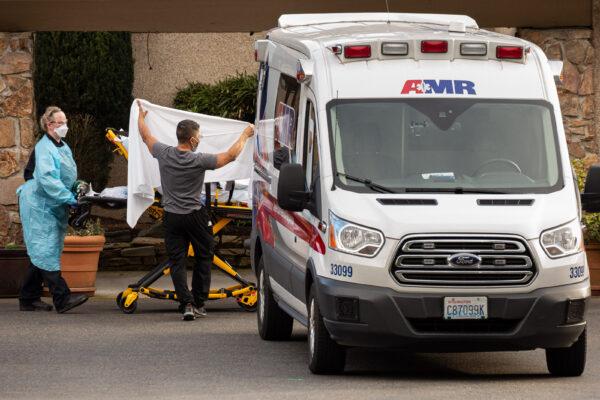 Healthcare workers transport a patient on a stretcher into an ambulance at Life Care Center of Kirkland in Kirkland, Wash., on Feb. 29, 2020. (David Ryder/Getty Images)