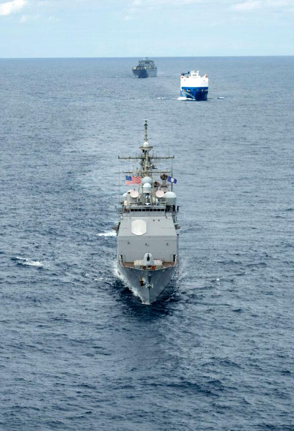 A convoy comprised of the Ticonderoga-class guided-missile cruiser USS Vella Gulf (CG 72) (R), the vehicle carrier MV Resolve (C), and the Military Sea Lift Command (MSC) roll-on roll-off cargo ship USNS Benavidez (T-AKR 306) steam in formation. (U.S. Navy Photo by Mass Communication Specialist 3rd Class Andrew Waters/Released)
