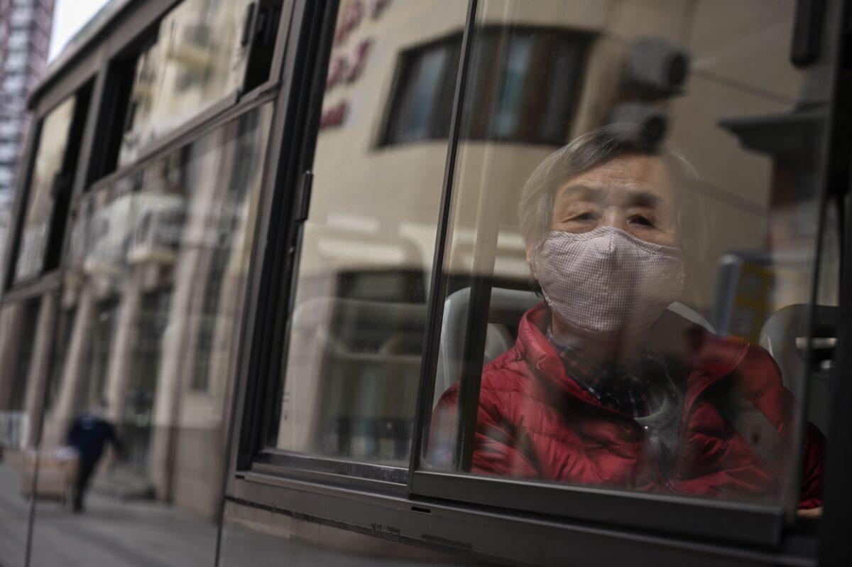 A woman wearing a face mask commutes on a bus in Shanghai on March 2, 2020. (Hector Retamal/AFP via Getty Images)