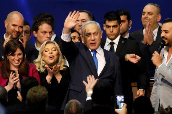 Israeli Prime Minister Benjamin Netanyahu stands next to his wife Sara as he waves to supporters following the announcement of exit polls in Israel's election at his Likud party headquarters in Tel Aviv, Israel, on March 3, 2020. (Amir Cohen/Reuters)