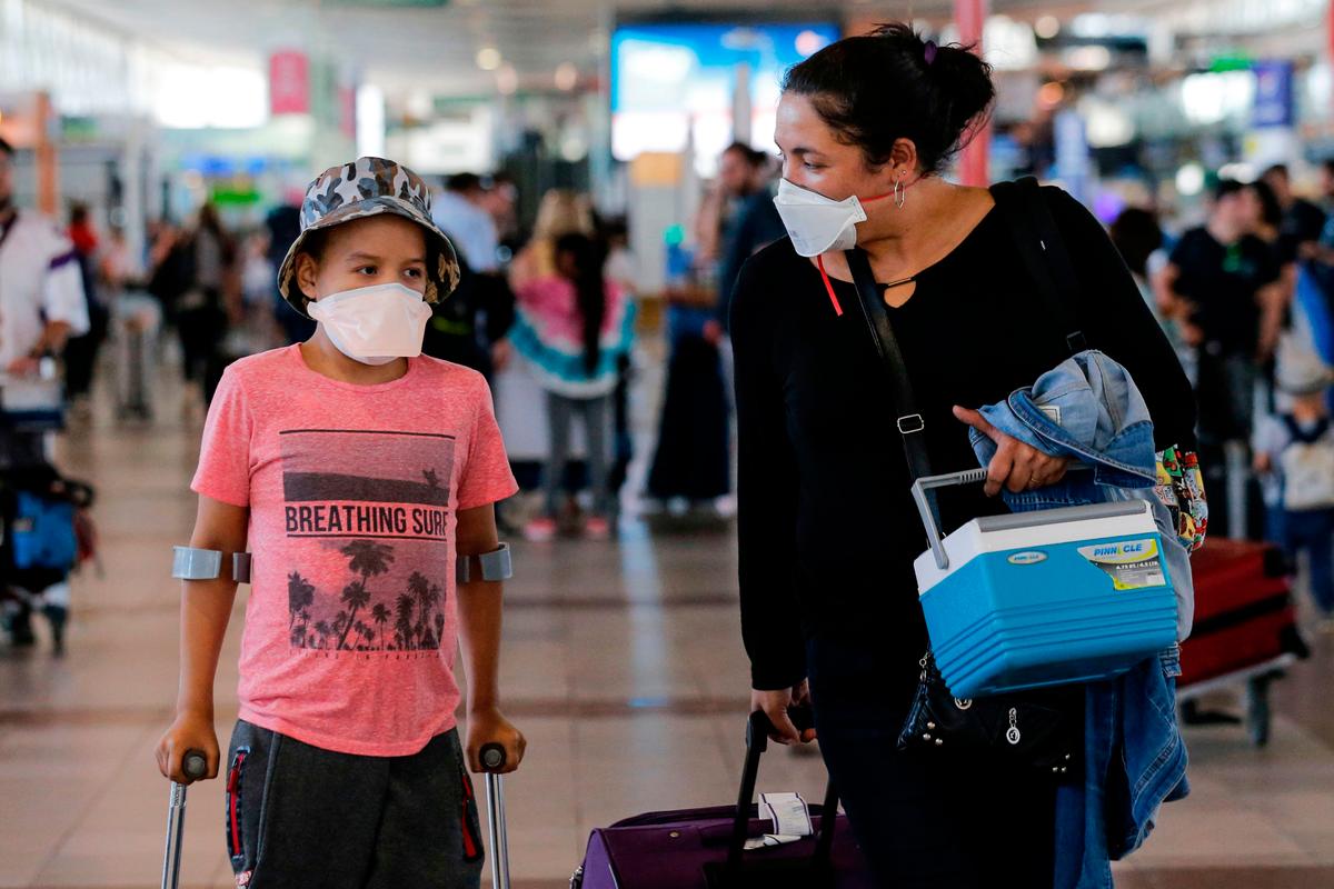 Passengers walk with protective masks at the Arturo Merino Benitez International Airport, in Santiago, Chile, on Mar. 3, 2020. (Javier Torres/AFP via Getty Images)
