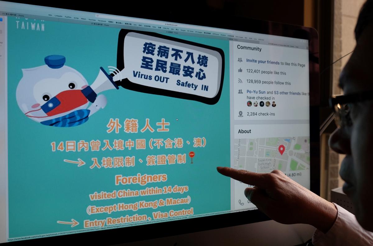A man points to a webpage from Taiwan's Ministry of Foreign Affairs Facebook account, used to promote the prevention of the deadly COVID-19 coronavirus, in Taipei, on Feb. 24, 2020. While China deploys stern communist slogans in its battle against a deadly new coronavirus, democratic Taiwan has embraced cuddly mascots and humor to ease public anxiety, tackle disinformation and prevent infections from spreading. ( Sam Yeh/AFP via Getty Images)