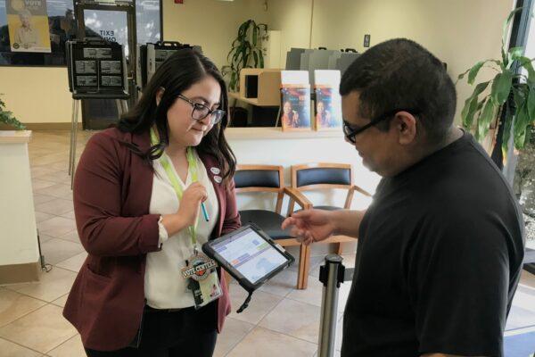 A volunteer helps a voter at the Orange County Registrar of Voters in Santa Ana, Calif., on March 3, 2020. (Chris Karr/The Epoch Times)