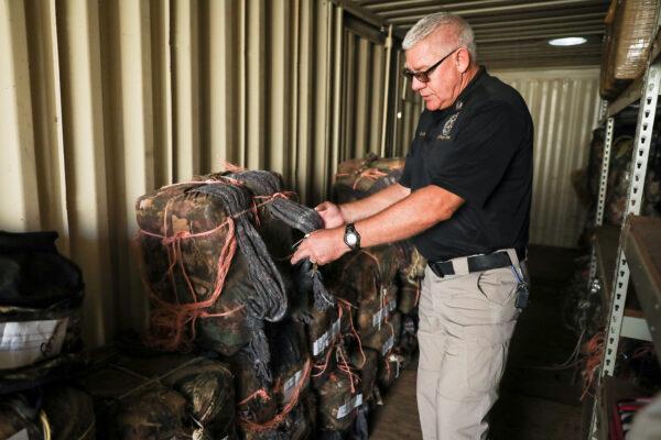 Scott Schlarb, evidence technician for the PInal County Sheriff’s Office, shows the seized bales of marijuana in Pinal County, Ariz., on Nov. 12, 2019. (Charlotte Cuthbertson/The Epoch Times)
