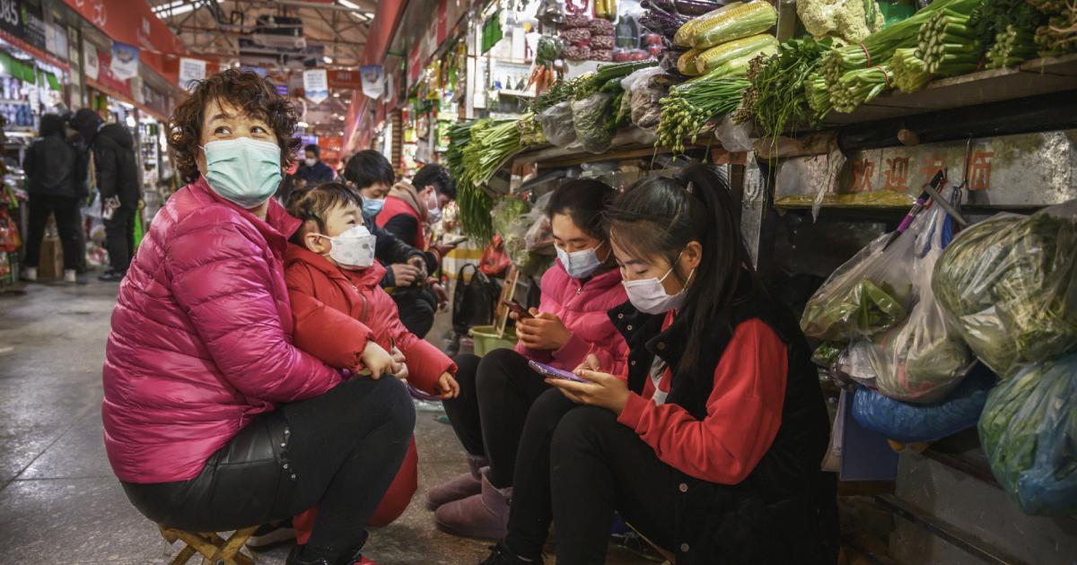 Chinese vegetable vendors wear protective masks as they wait for customers at a local market in Beijing, China, on March 4, 2020. (Kevin Frayer/Getty Images)