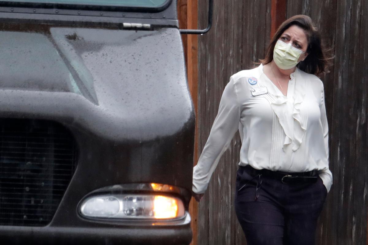 An employee at the Life Care Center in Kirkland, Wash., near Seattle, wears a mask as she walks near a UPS truck during a package delivery on March 2, 2020. (Ted S. Warren/AP Photo)