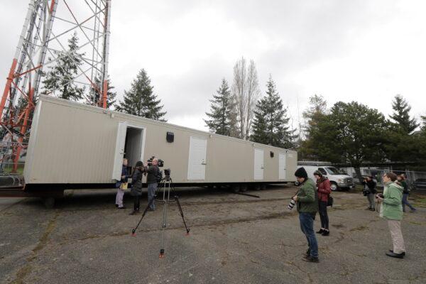 Reporters and photographers at the site in South Seattle where King County will be placing several temporary housing units to house patients undergoing treatment and isolation in response to the COVID-19 coronavirus, on March 3, 2020. (Ted S. Warren/AP Photo)