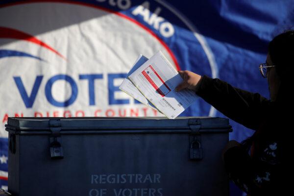 A poll worker drops in drive through ballots into a ballot box as fourteen states including California hold primaries on Super Tuesday in San Diego, California, U.S., March 3, 2020. (Mike Blake/Reuters)