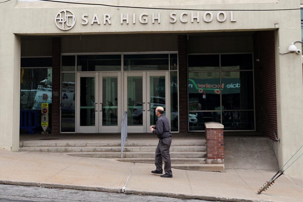 A man walks past SAR High School, which has been shut down due to COVID-19 in the Bronx borough of New York City on March 3, 2020. (Carlo Allegri/Reuters)