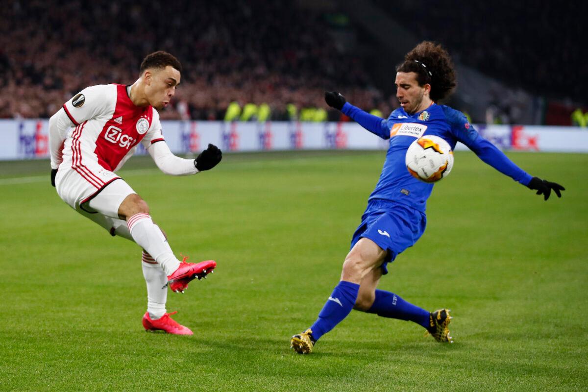 Ajax's Sergino Dest (L) and Getafe's Marc Cucurella vie for the ball during a Europa League soccer match between Ajax and Getafe in Amsterdam, Netherlands, on Feb. 27, 2020. (AP Photo/Peter Dejong)