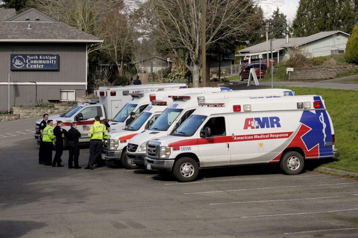 Ambulances are seen in a staging area at the North Kirkland Community Center, which is a short drive from the Life Care Center of Kirkland, the long-term care facility linked to several confirmed coronavirus cases in the state, in Kirkland, Wash., on March 4, 2020. (David Ryder/Reuters)