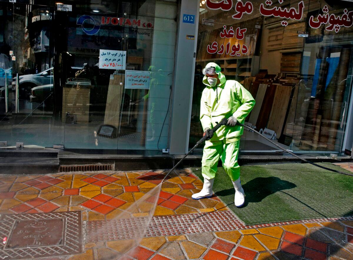 Iranian fire fighters and municipality workers disinfect a street in the capital Tehran for coronavirus COVID-19 on March 5, 2020. (Stringer/AFP via Getty Images)