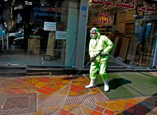Iranian fire fighters and municipality workers disinfect a street in the capital Tehran for corona virus COVID-19 on March 5, 2020. (Stringer/AFP via Getty Images)