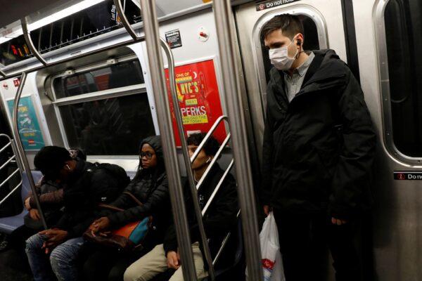 A man in a face mask rides the subway in Manhattan after further cases of coronavirus were confirmed in New York on March 5, 2020. (Andrew Kelly/Reuters)