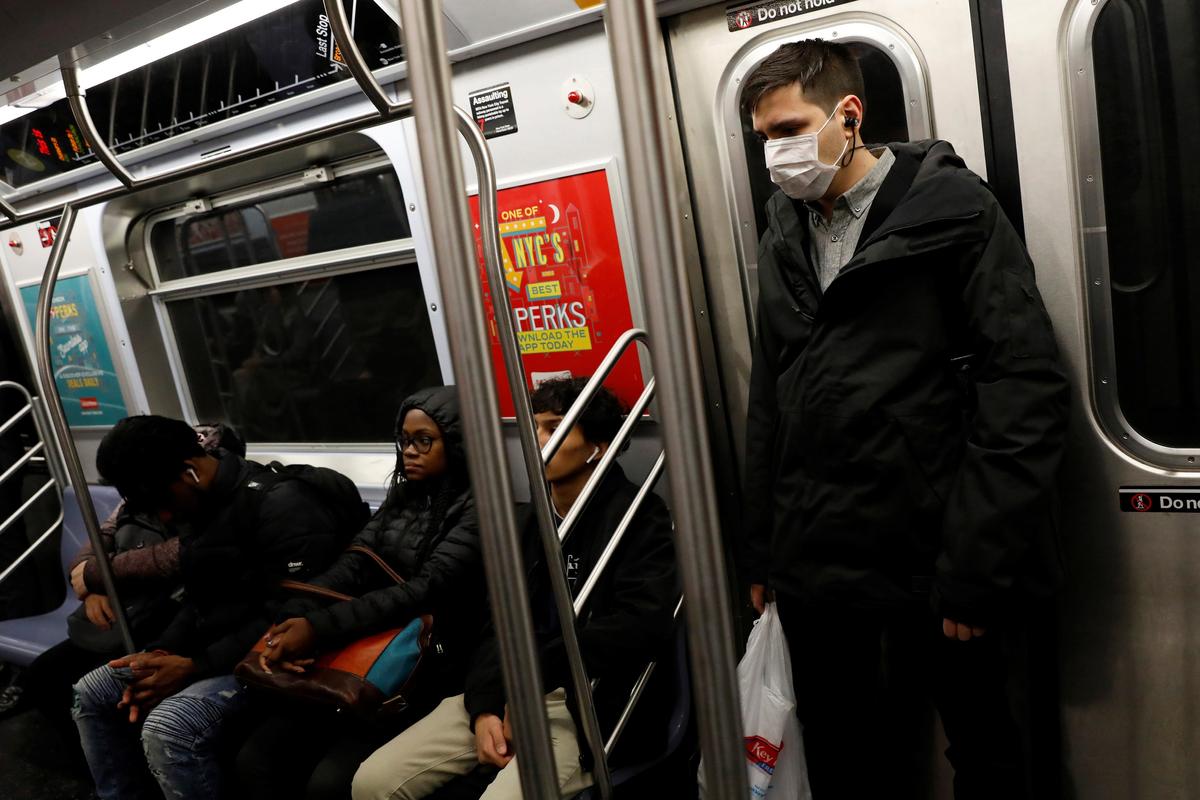 A man in a protective mask rides the subway in Manhattan, New York City, after further cases of coronavirus were confirmed in New York on March 5, 2020. (Andrew Kelly/Reuters)