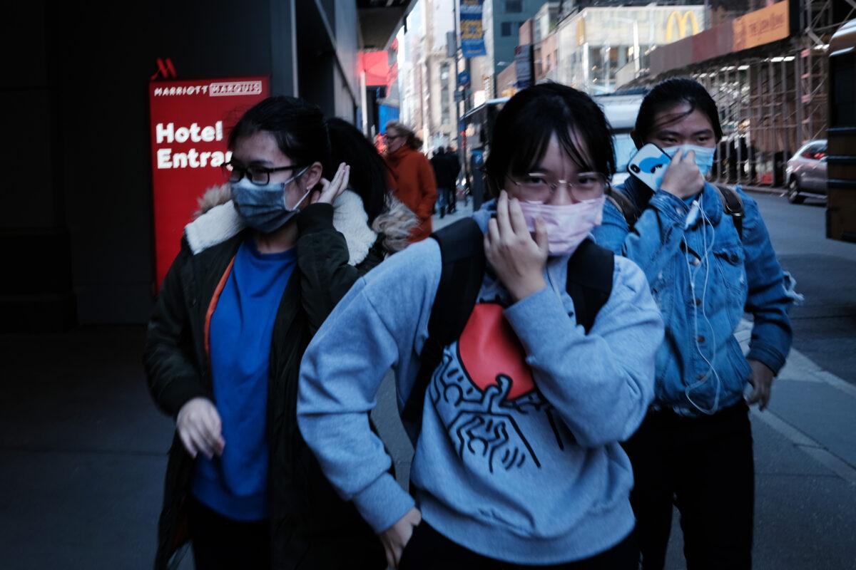 People walk through Manhattan with surgical masks as fears of the coronavirus spreading through the U.S. increase in New York City on March 4, 2020. (Spencer Platt/Getty Images)