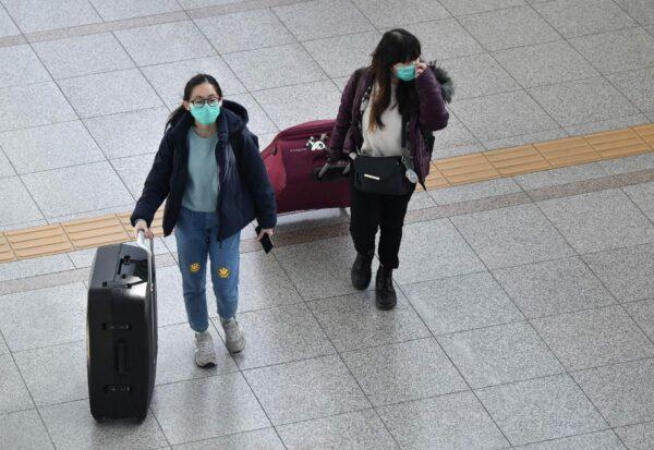 Passengers wearing face masks walk through a railway station in Seoul on March 4, 2020. (Jung Yeon-Je/AFP via Getty Images)