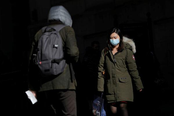 A woman in a face mask walks in the downtown area of Manhattan, New York City, after further cases of the new coronavirus were confirmed in New York on March 5, 2020. (Andrew Kelly/Reuters)