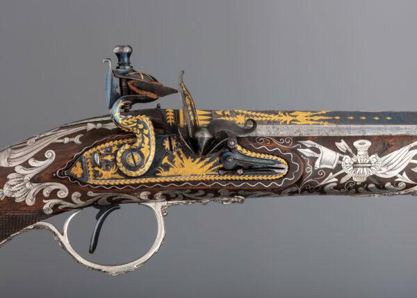 Detail of the flintlock pistol's blued steel lock and barrel engraved and gold-inlaid with trophies of arms and foliage; 1800–1801, by gunmaker Samuel Brunn and silversmith Michael Barnet. British, London. Purchased through the Harris Brisbane Dick Fund and gift of George D. Pratt, by exchange, 1992. (The Metropolitan Museum of Art)