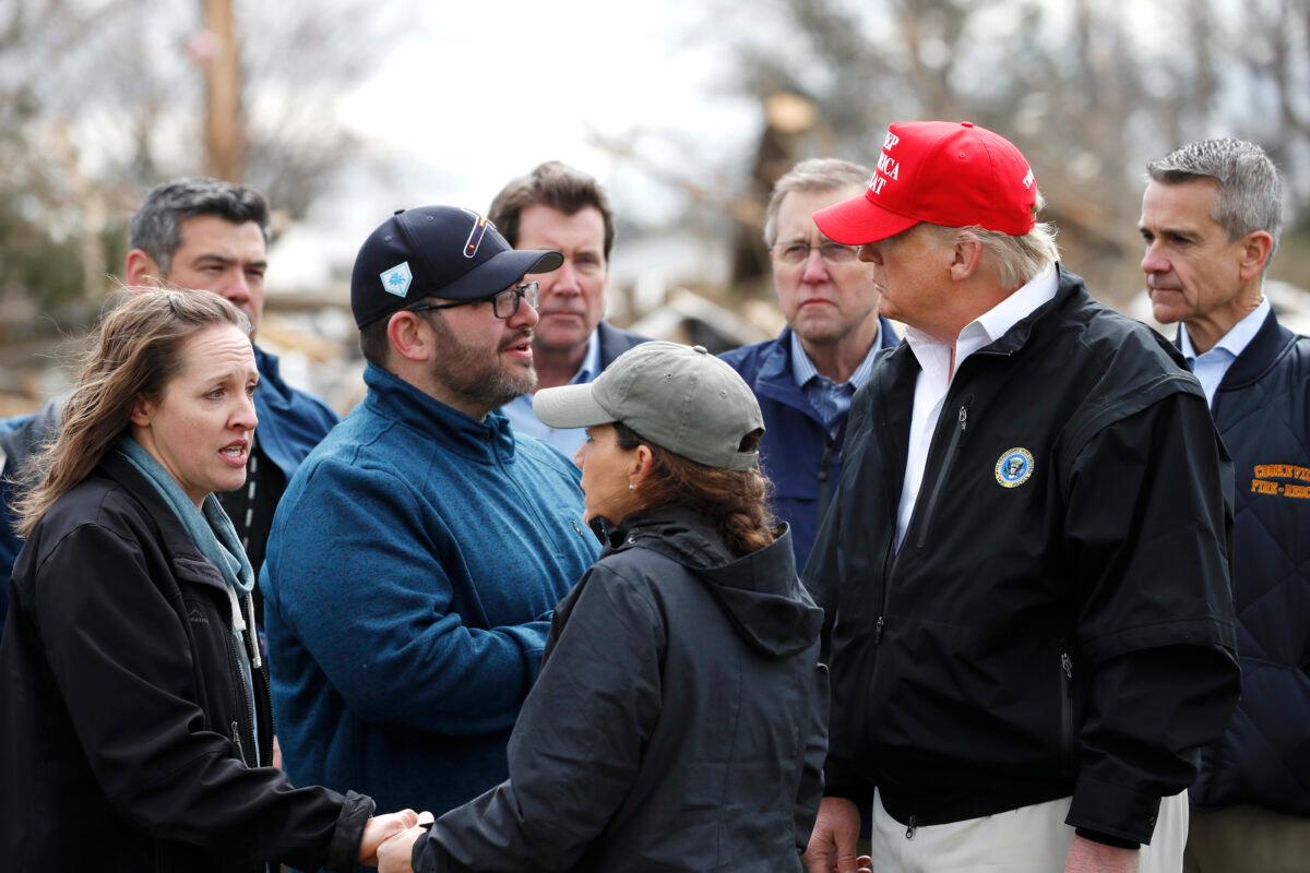 President Donald Trump, accompanied by Tennessee First Lady Maria Lee (C), speaks with residents Matt and Angela Suggs as they tour damage from a recent tornado, in Cookeville, Tenn., on March 6, 2020. (Alex Brandon/AP Photo)