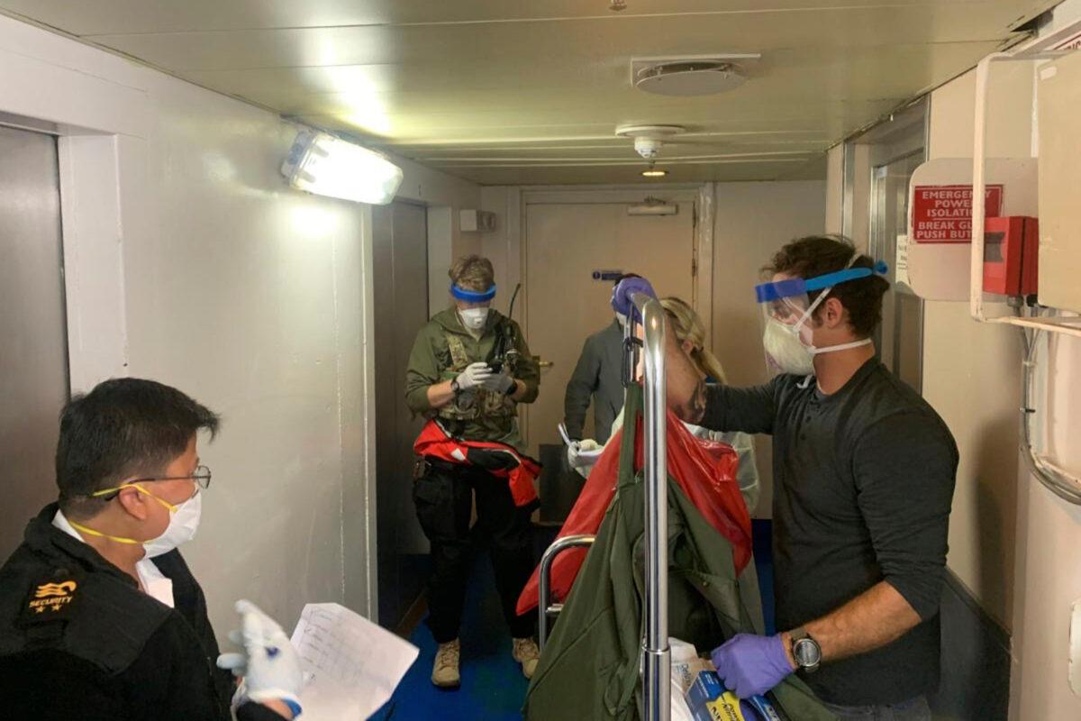 A group of medical personnel with the 129th Rescue Wing, working alongside individuals from the Centers for Disease Control and Prevention, don protective equipment after delivering virus testing kits to the Grand Princess cruise ship off the coast of California on March 5, 2020. (Chief Master Sgt. Seth Zweben/California National Guard via AP)