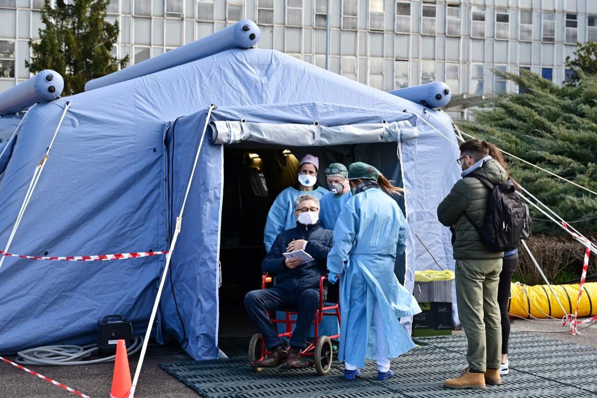 A man receives assistance in the a pre-triage medical tent in front of the Cremona hospital, northern Italy, on March 4, 2020. (Miguel Medina/AFP via Getty Images)