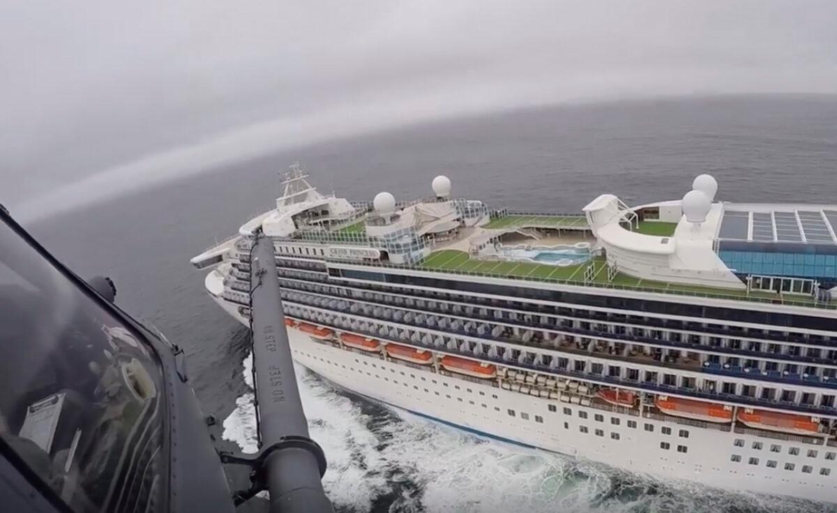 In this image from video, provided by the California National Guard, a helicopter carrying airmen with the 129th Rescue Wing flies over the Grand Princess cruise ship off the coast of California on March 5, 2020. (California National Guard via AP)
