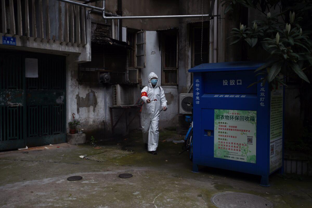 A community worker in protective suit disinfects a residential compound in Wuhan, the epicenter of the novel coronavirus outbreak, Hubei Province, China on March 6, 2020. (Stringer/Reuters)
