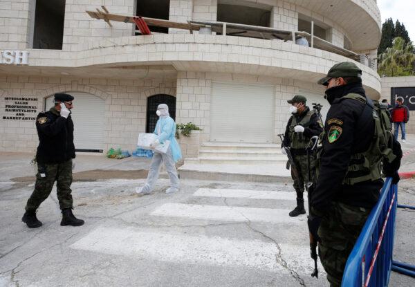 Members of Palestinian security forces stand guard near Angel Hotel where, according to a Palestinian government official, a group of American visitors have been quarantined as part of precautions against the coronavirus, in Beit Jala town in the Israeli-occupied West Bank on March 7, 2020. (Mussa Qawasma/Reuters)