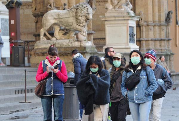 People wearing protective masks walk through Florence as Italy battles a coronavirus outbreak, in Florence, Italy, on March 7, 2020. (Jennifer Lorenzini/Reuters)