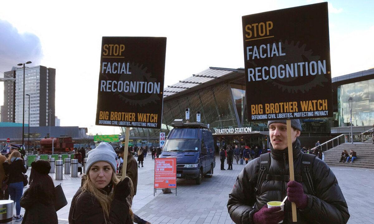 Rights campaigner Silkie Carlo (L) demonstrates in front of a mobile police facial recognition facility outside a shopping centre in London, on Feb. 11, 2020. (Kelvin Chan/AP Photo)