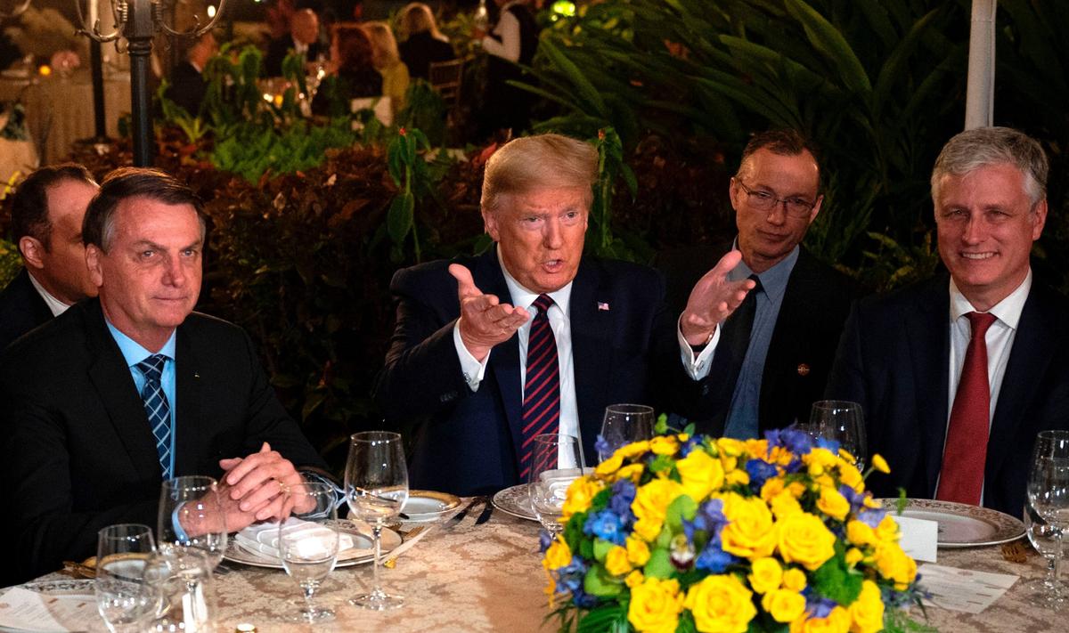President Donald Trump (C) speaks with Brazilian President Jair Bolsonaro (L), alongside national security adviser Robert O'Brien (R) during a dinner at Mar-a-Lago in Palm Beach, Fla., on March 7, 2020. (Jim Watson/AFP via Getty Images)