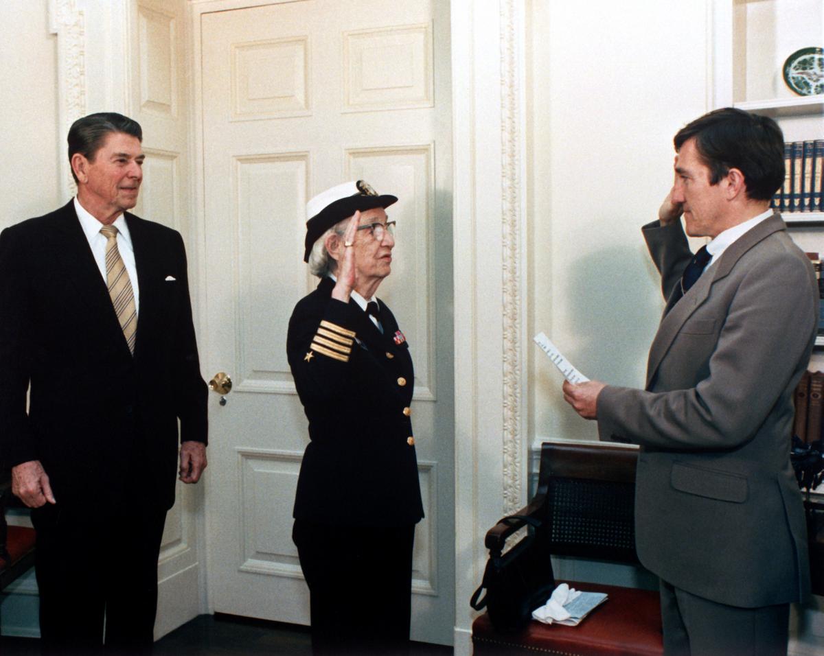 Secretary of the Navy, John Lehman, right, promotes Capt. Grace Hopper to the rank of commodore in a ceremony at the White House. President Ronald Reagan is at the left. (©Wikimedia Commons | <a href="https://commons.wikimedia.org/wiki/File:Grace_Hopper_being_promoted_to_Commodore.JPEG">Pete Souza</a>)