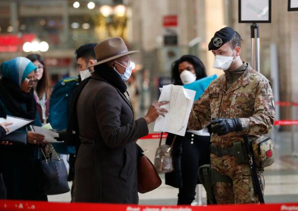 Police officers and soldiers check passengers leaving from Milan's main train station, Italy, on March 9, 2020. (Antonio Calanni/AP Photo)