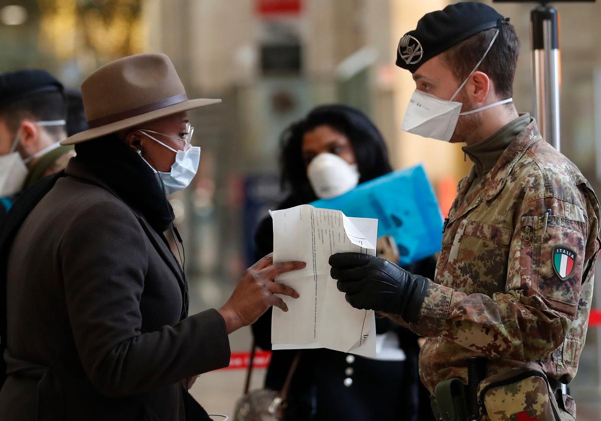 Police officers and soldiers check passengers leaving from Milan main train station, Italy, on March 9, 2020. (Antonio Calanni/AP Photo)
