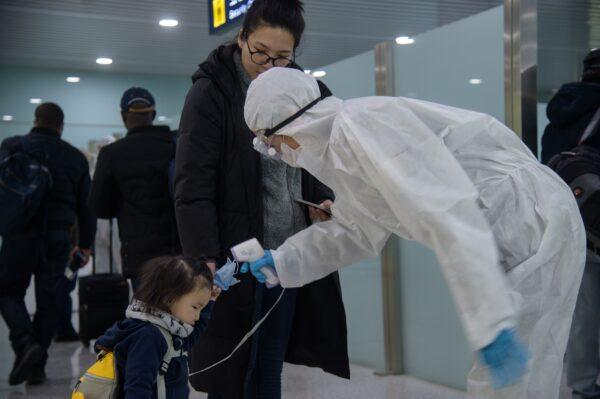 A child has her temperature taken as foreign diplomats and embassy staff prepare to board a flight to Vladivostok at Pyongyang International Airport on March 9, 2020. (Kim Won Jin/AFP/Getty Images)